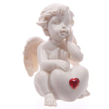 Weißer Cherub sitzt mit rotem Herz-Edelstein